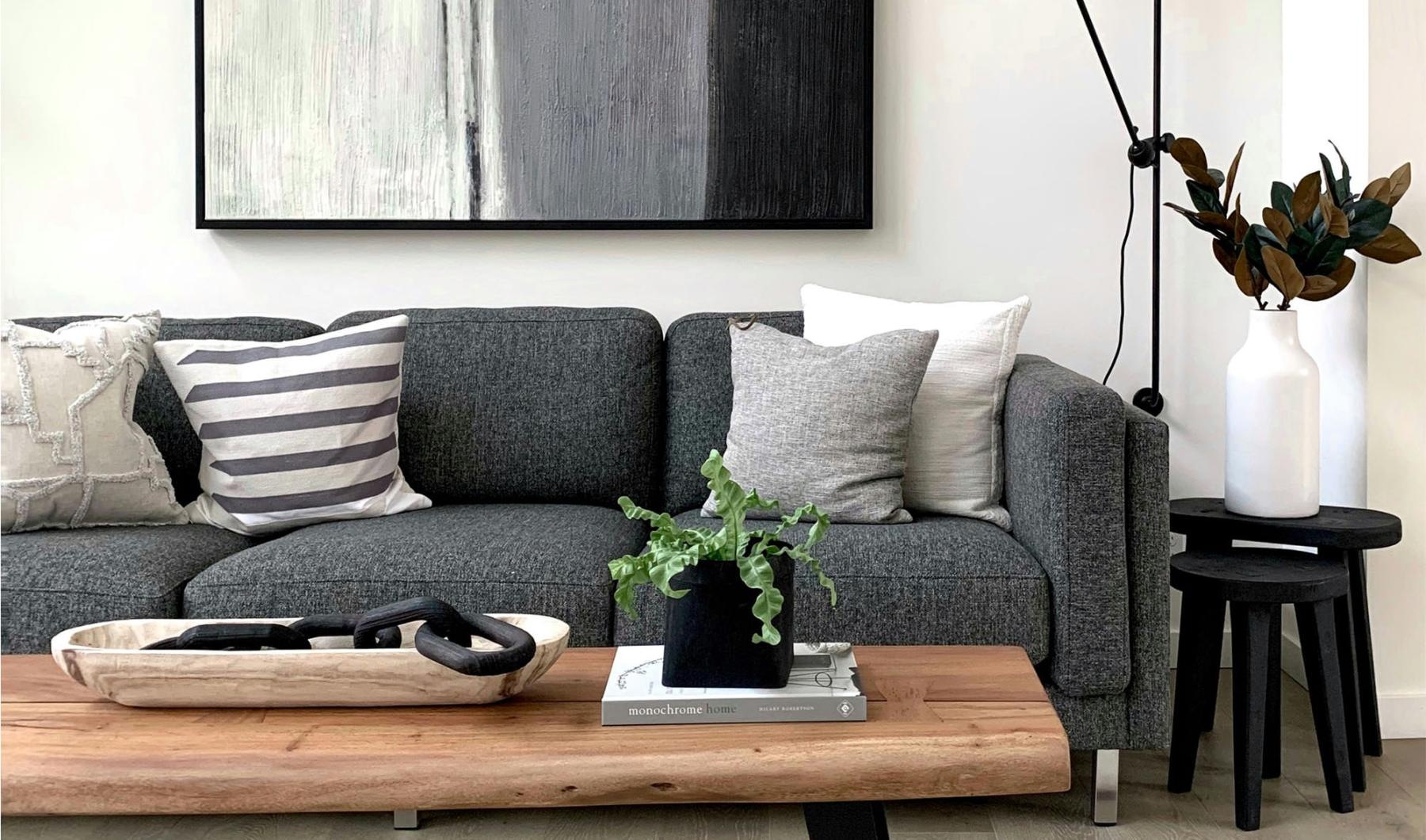 a couch with a coffee table with a plant and decor on it